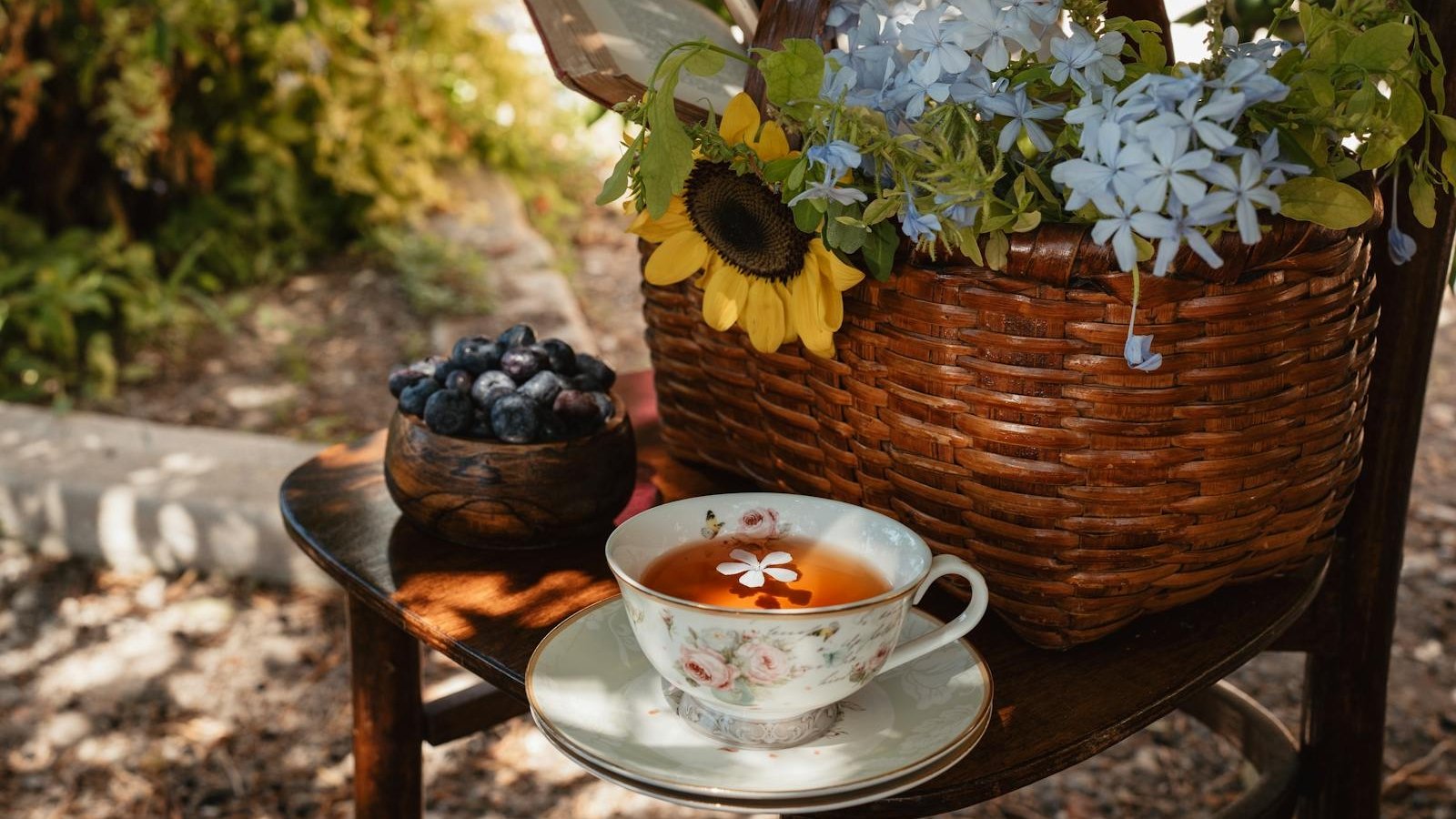 A basket with flowers and a cup of tea on a table